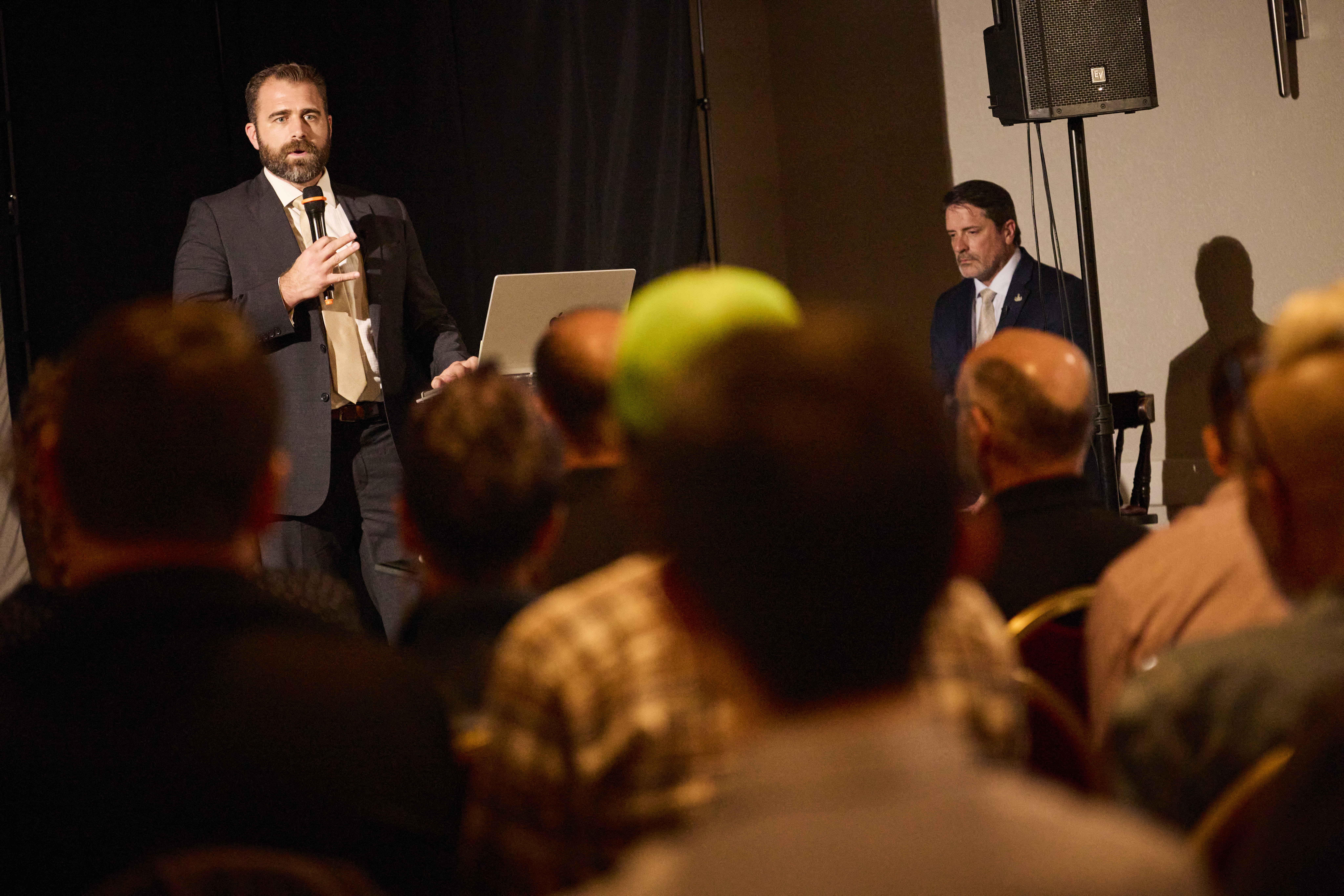 Dr. Chris Slininger speaking to a seated conference audience with a moderator behind him